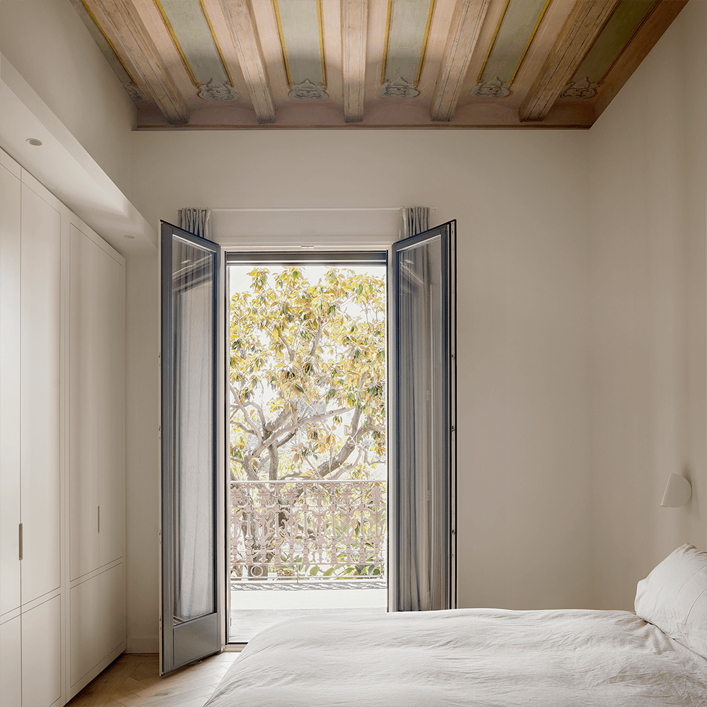 Garden-view bedroom with restored heritage ceiling